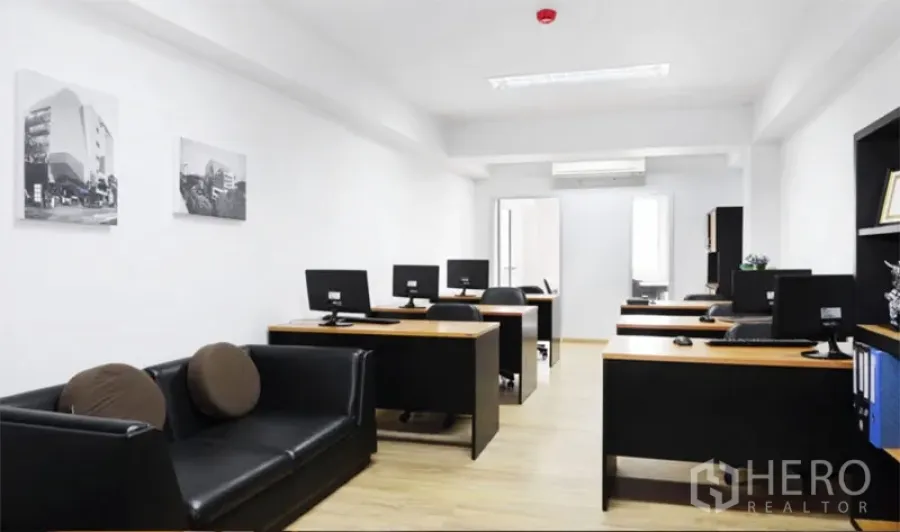Office Space for rent in Khlong Toei, Bangkok - Bright open-plan office with black desks, computers, sofa and wood flooring near BTS Thong Lo in Bangkok.