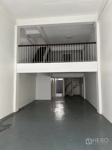 พื้นที่ขายปลีก ให้เช่าในWatthana, Bangkok - โถงร้านลึก เพดานสูงสองชั้น พร้อมราวกั้นชั้นลอย ผนังสีขาว.