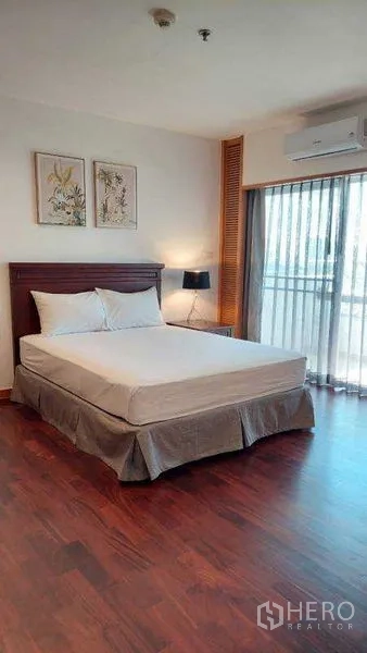 房间 出租 - 采光良好的卧室，带阳台门、木地板与空调。