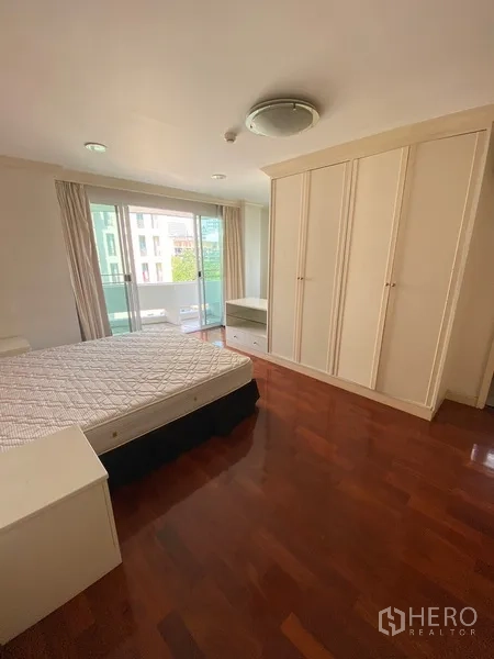 อพาร์ทเมนท์ ให้เช่าในWatthana, Bangkok - ห้องนอนที่สองพร้อมตู้เสื้อผ้าบิลท์อิน พื้นไม้ และประตูกระจกเปิดสู่ระเบียง