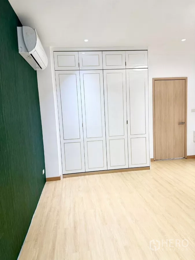 สำนักงานที่บ้าน ให้เช่าหรือขายในWang Thonglang, Bangkok - ห้องนอนผนังสีเขียว ตู้บิลท์อินสีขาว และพื้นไม้