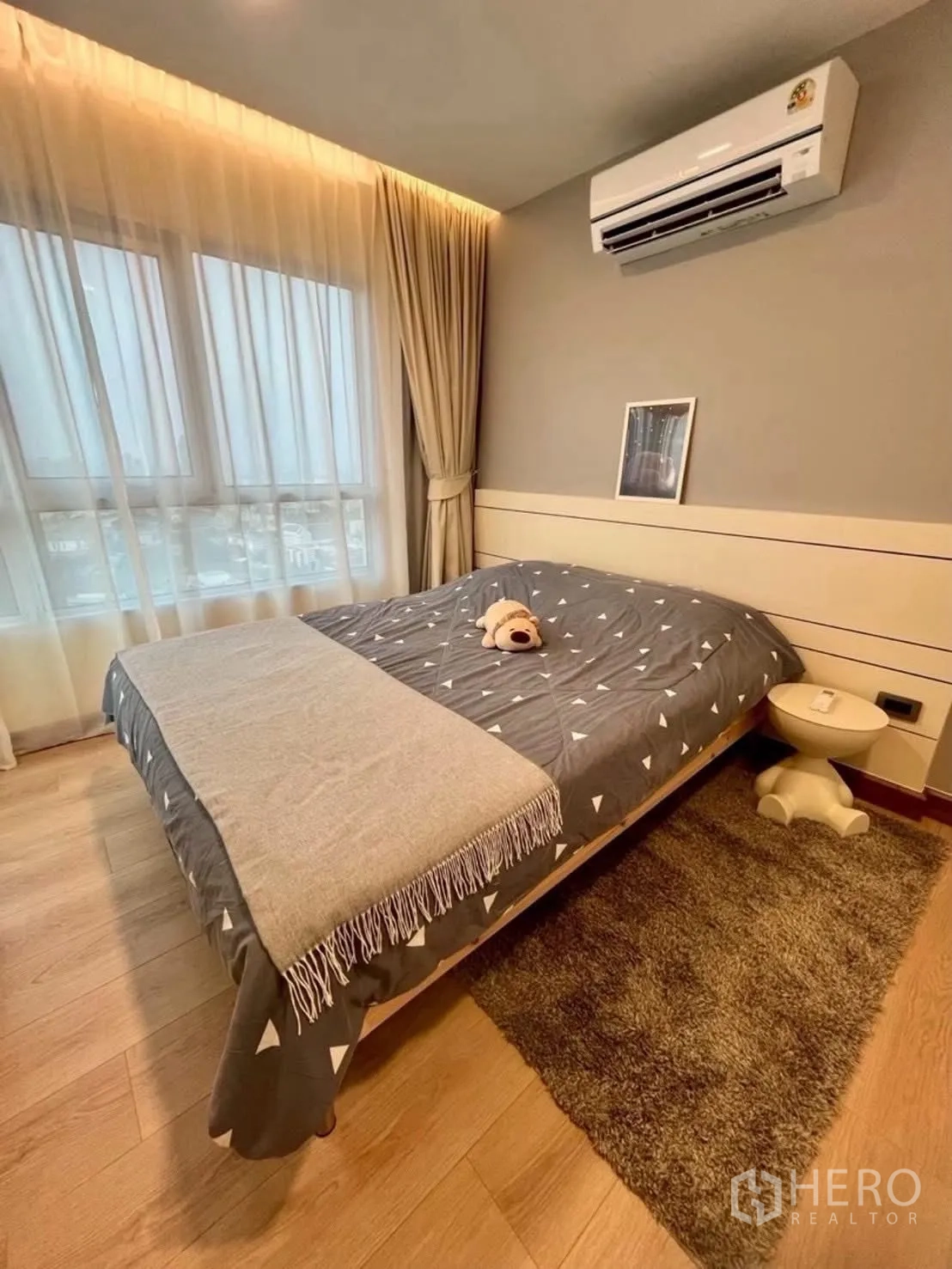 Condominium for rent in Huai Khwang, Bangkok - Cozy bedroom with double bed, wood flooring, and air conditioner.