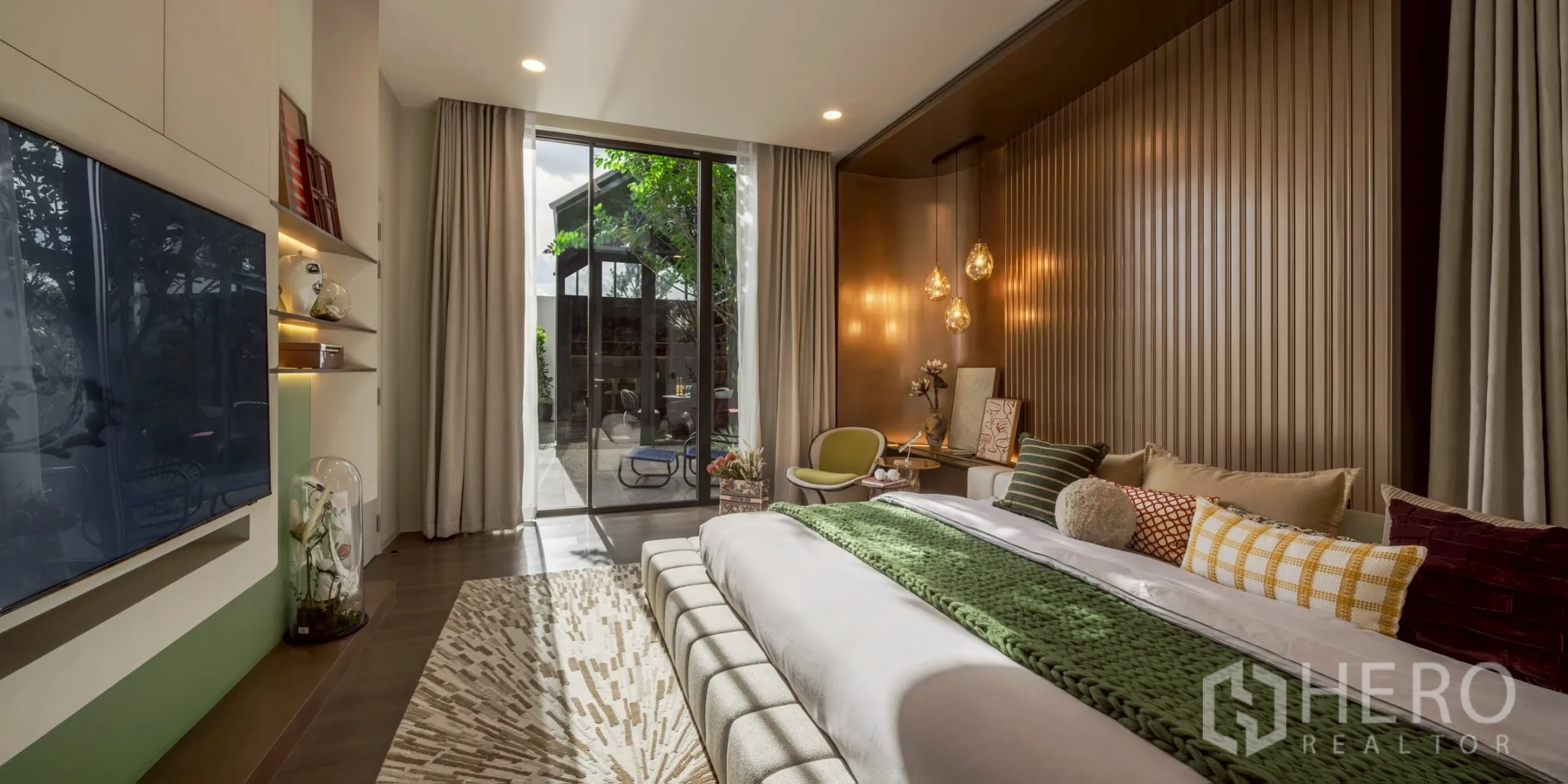 Detached House for rent in Saphan Sung, Bangkok - Ground‑floor bedroom with sliding doors to terrace, warm lighting and textured wall.