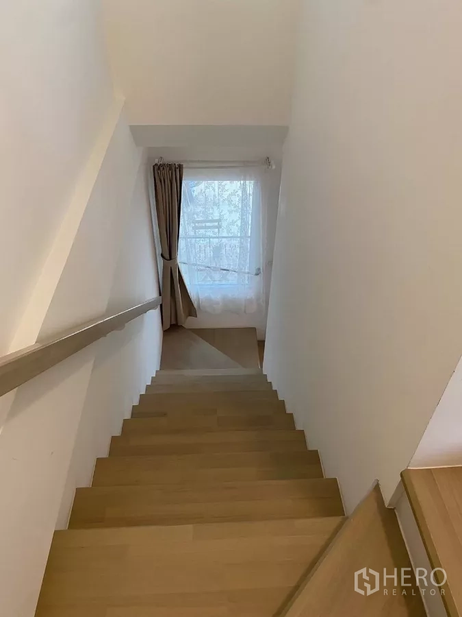 联排别墅 出租在Prawet, Bangkok - 木质楼梯带扶手，通向采光窗。