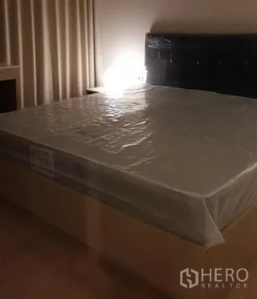 คอนโด ให้เช่าในWatthana, Bangkok - ห้องนอนอบอุ่นเตียงควีนไซซ์ หัวเตียงบุนวม และโคมไฟข้างเตียง