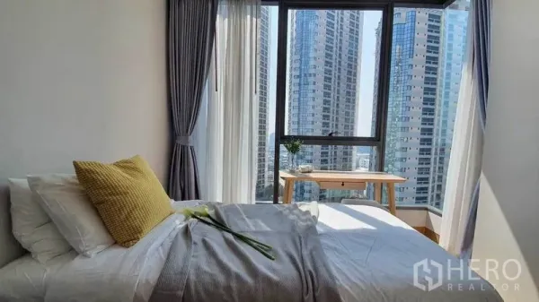 公寓 出租在Khlong Toei, Bangkok - 转角卧室配落地窗与纱帘，眺望曼谷城市天际线。