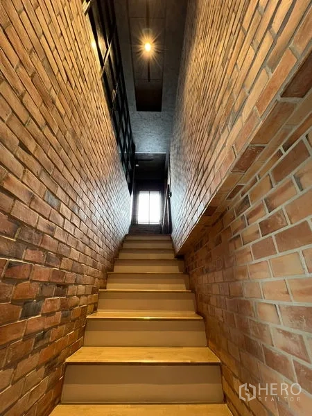 联排别墅 出租在Saphan Sung, Bangkok - 砖墙包裹的楼梯间通向楼上。