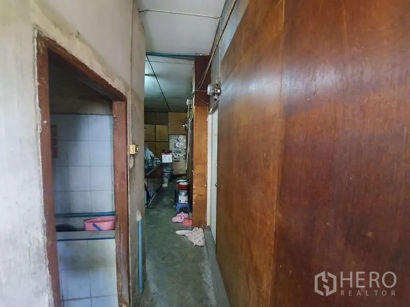 ทาวน์เฮาส์ ให้เช่า - โถงแคบผนังไม้ มีประตูทางเข้าห้องน้ำกระเบื้อง