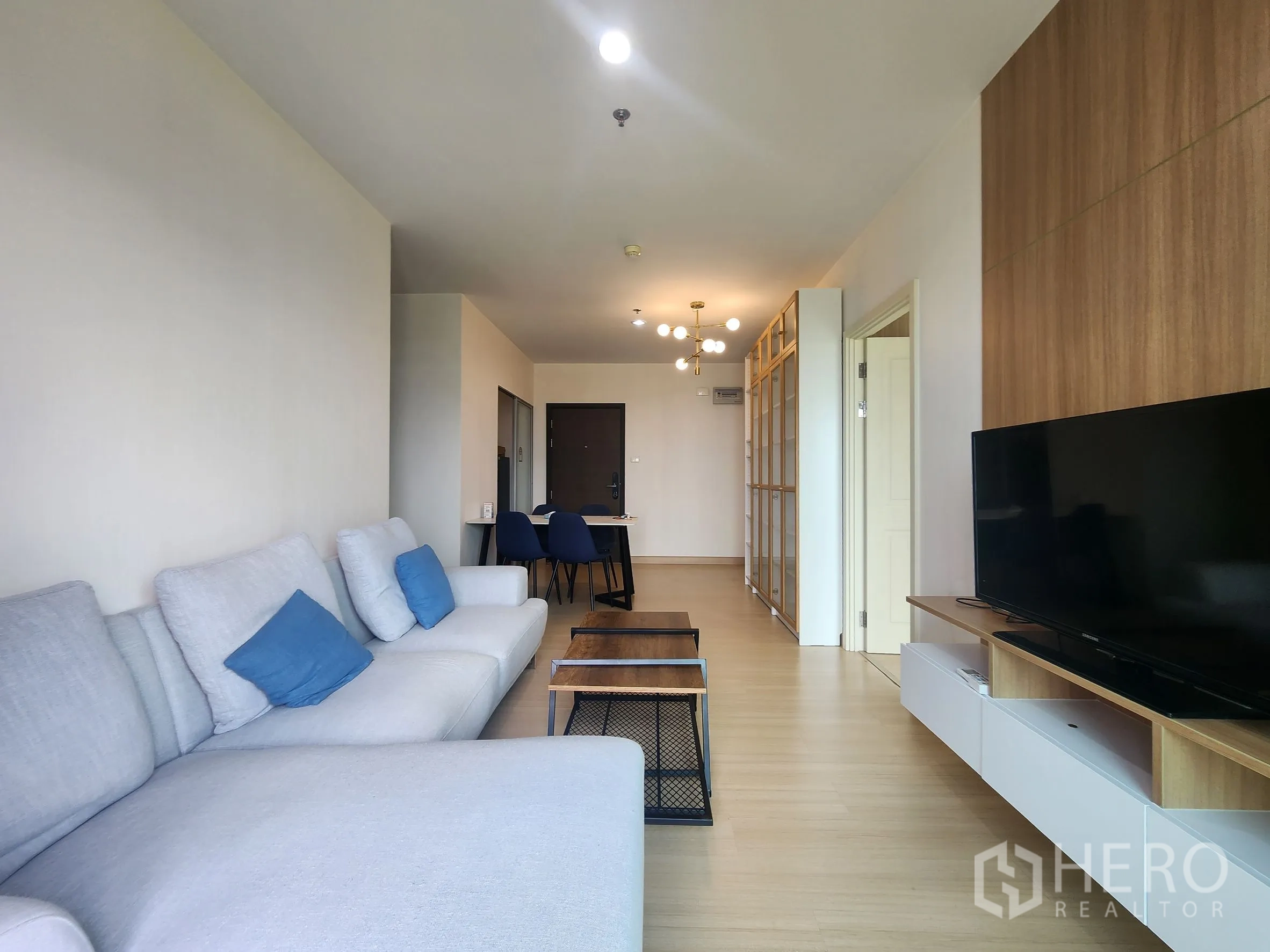 คอนโด for rent in Huai Khwang, Bangkok - ห้องนั่งเล่นมองสู่โซนรับประทานอาหาร ทีวีบนชั้นลอย โซฟาตัวใหญ่ โคมไฟเพดาน และชั้นกั้นห้อง