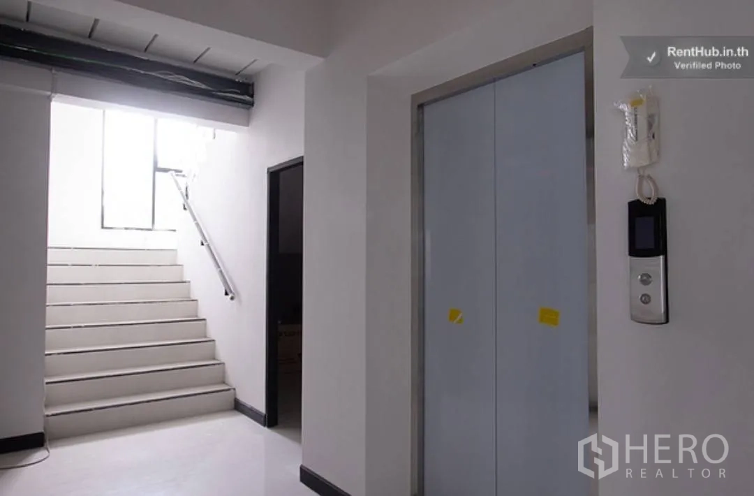 Apartment for rent in Phra Khanong, Bangkok - Interior hallway showing an elevator next to a stairwell.