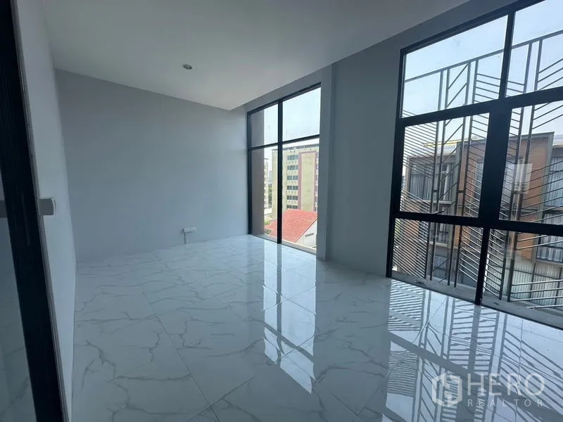 Home Office for rent - Sunlit meeting room finished with white marble tiles and tall windows.