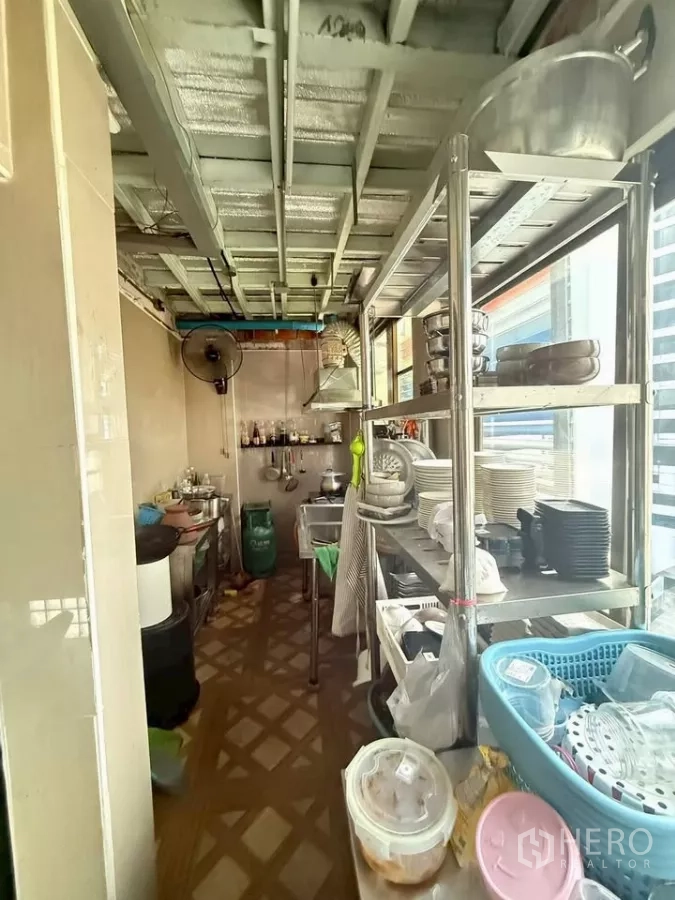 零售空间 出租在Watthana, Bangkok - 狭长商用厨房，不锈钢置物架与炊具靠窗陈列