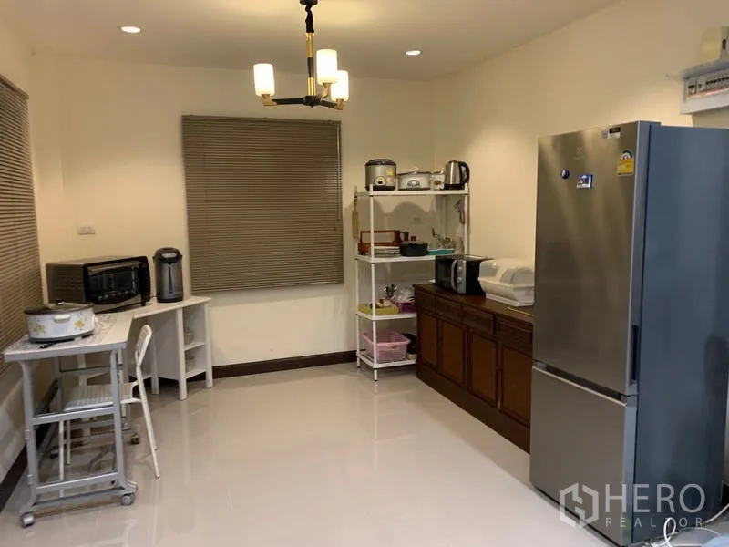 Detached House for rent in Khlong Sam Wa, Bangkok - Bright eat-in kitchen with fridge, shelving, small table, and ceiling light.