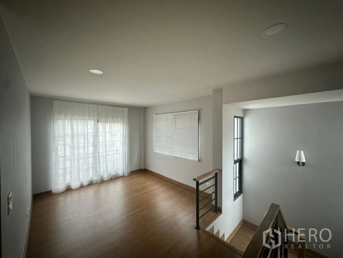 บ้านเดี่ยว for rent in Bang Phli, Samut Prakan - โถงชั้นบนปูพื้นลายไม้ มีหน้าต่างและผ้าม่านโปร่ง