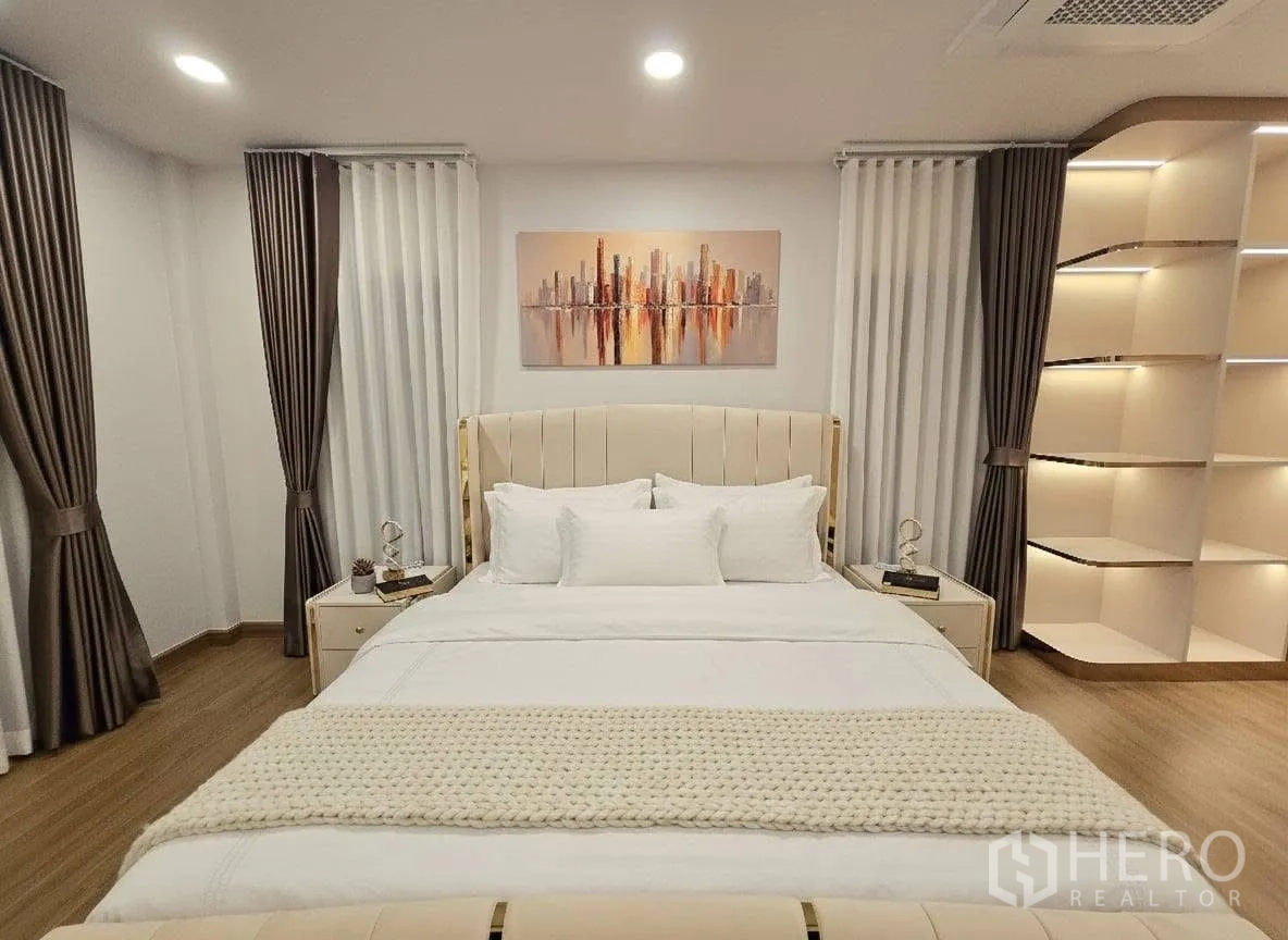 Detached House for rent or sale in Bang Phli, Samut Prakan - Master bedroom with king bed, cityscape artwork, dual curtains and built‑in shelving.