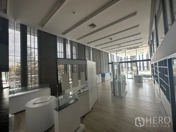 พื้นที่ขายปลีก ให้เช่าในBang Phli, Samut Prakan - โชว์รูมสว่างไสว มีหน้าต่างกระจกเต็มผนังและตู้แสดงสินค้าใกล้ทางเข้า