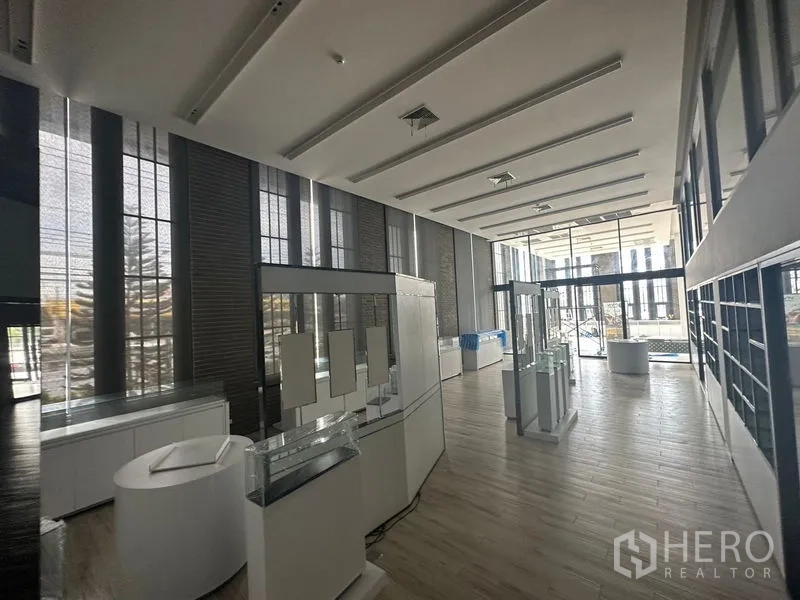 พื้นที่ขายปลีก ให้เช่าในBang Phli, Samut Prakan - โชว์รูมสว่างไสว มีหน้าต่างกระจกเต็มผนังและตู้แสดงสินค้าใกล้ทางเข้า