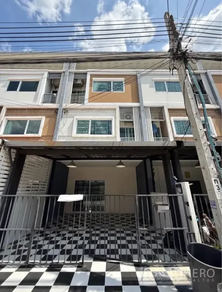 Townhouse for rent in Suan Luang, Bangkok - Three-storey townhouse facade with gated carport and checkered tiles in Suan Luang.