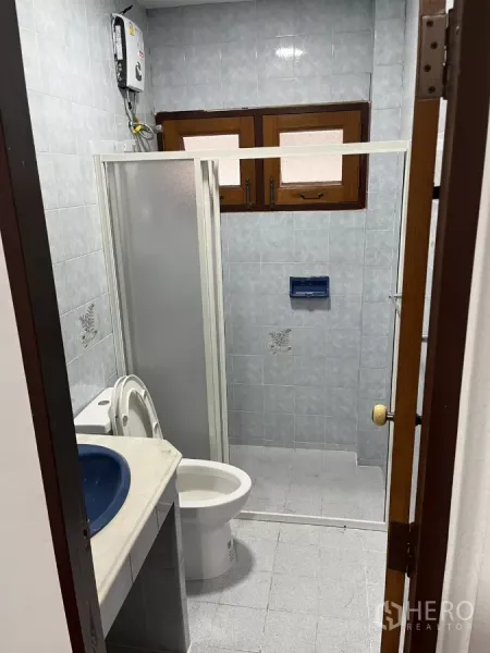 บ้าน ให้เช่าในWatthana, Bangkok - ห้องน้ำพร้อมตู้ชาวเวอร์ โถสุขภัณฑ์ และเคาน์เตอร์อ่างล้างหน้า ใต้หน้าต่างบานเล็ก.