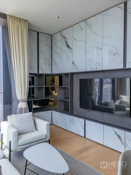 Condominium for rent - Living area with marble built-in media wall, shelving and large TV.