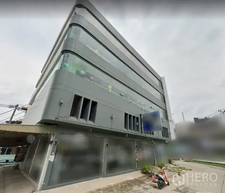 อาคารพาณิชย์ ให้เช่าในSuan Luang, Bangkok - อาคารพาณิชย์หลายชั้นสไตล์โมเดิร์น หน้ากระจกโค้ง ผนังสีเทา ชั้นล่างบานม้วนและป้ายว่าง ในเขตสวนหลวง กรุงเทพฯ