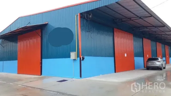 工厂 出租在Khlong Luang, Pathum Thani - 近距离外观，多个工厂卷门在长雨棚下，前方设停车区。