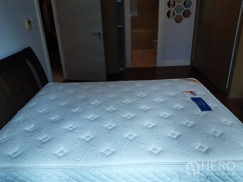 คอนโด ให้เช่าหรือขายในKhlong Toei, Bangkok - ห้องนอนที่สองมุมมองสู่ประตูและห้องน้ำในตัว พื้นไม้โทนอุ่น