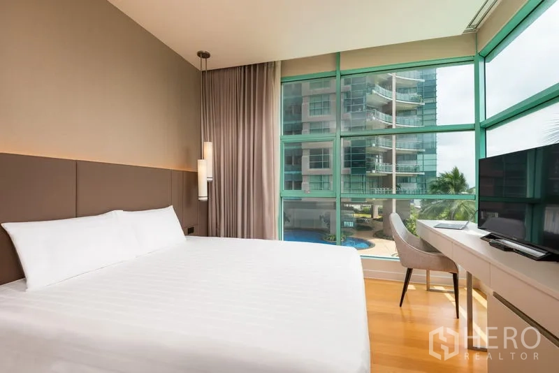 คอนโด ให้เช่าในBang Kho Laem, Bangkok - ห้องนอนสว่าง เตียงคิง โต๊ะทำงาน และหน้าต่างมุมแบบเต็มผนอง มองเห็นสระว่ายน้ำและตึกข้างเคียง