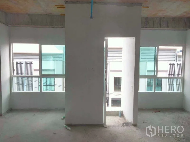 Office Space for rent or sale - Unfinished partitioned room with multiple windows and a central doorway.