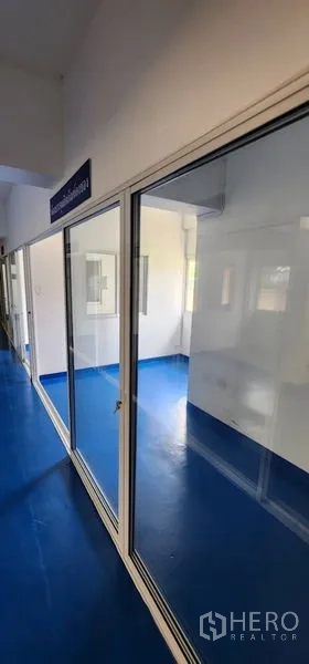 货栈 出租在Bueng Kum, Bangkok - 一排推拉玻璃门通向分隔工作区，蓝色地坪。