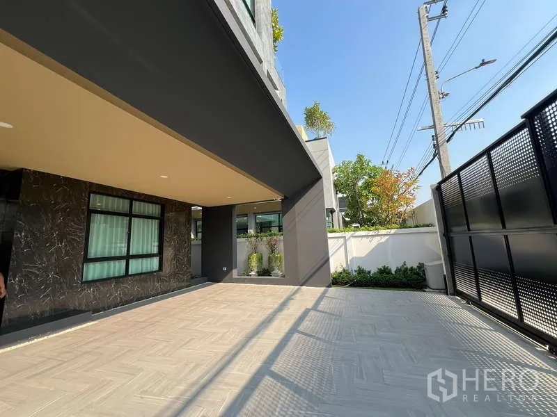 Detached House for sale in Suan Luang, Bangkok - Covered carport and paved driveway behind secure metal gate