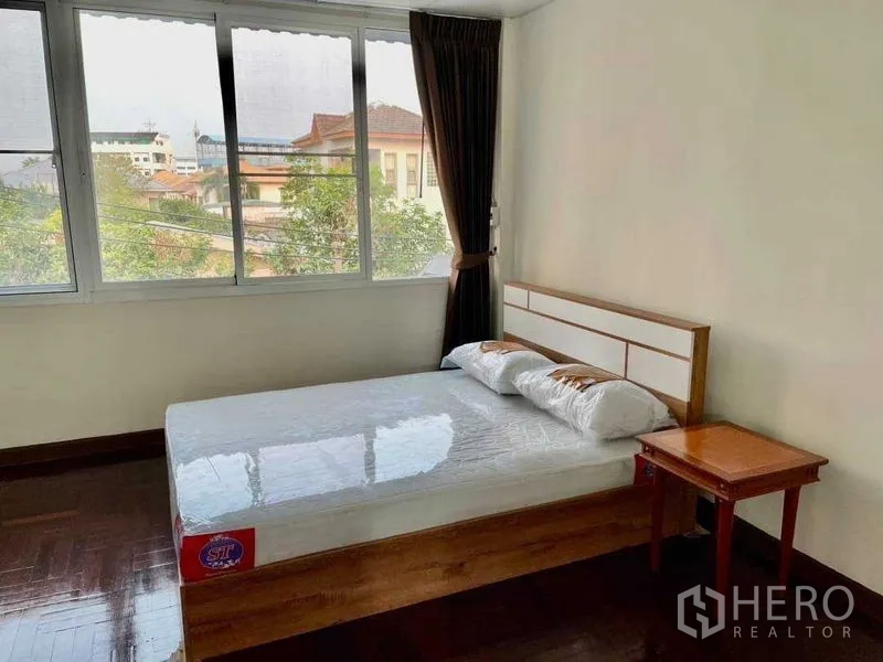Home Office for rent or sale in Watthana, Bangkok - Bedroom with a double bed, large windows and neighborhood views.