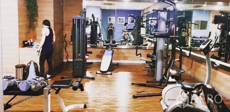 Condominium for rent in Ratchathewi, Bangkok - Fitness room equipped with free weights, cardio machines and a mirrored wall.
