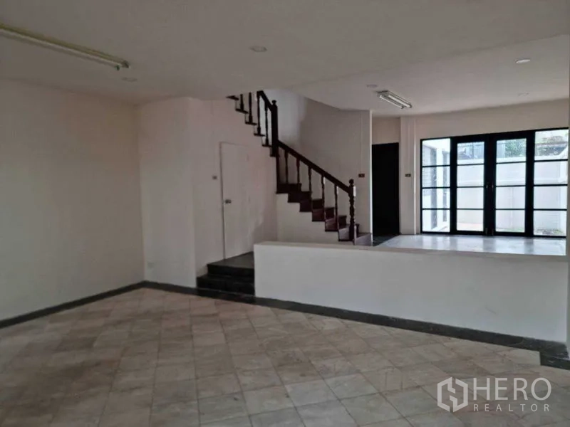 ทาวน์เฮาส์ ให้เช่าในWang Thonglang, Bangkok - พื้นที่รับแขกแบบสเต็ปพร้อมบันไดไม้ และประตูกระจกคู่เชื่อมต่อสู่ชานบ้าน