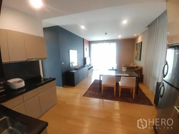 คอนโด ให้เช่าหรือขายในWatthana, Bangkok - ครัวสมัยใหม่ท็อปหินสีดำ เชื่อมต่อสู่โซนรับประทานอาหารและห้องนั่งเล่นที่สว่าง