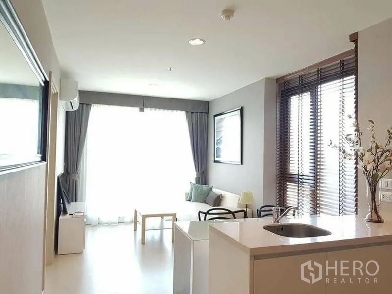 คอนโด ให้เช่าหรือขายในKhlong Toei, Bangkok - ห้องนั่งเล่นโปร่งสว่าง พร้อมครัวไอส์แลนด์ โซฟา และหน้าต่างใหญ่พร้อมผ้าม่าน