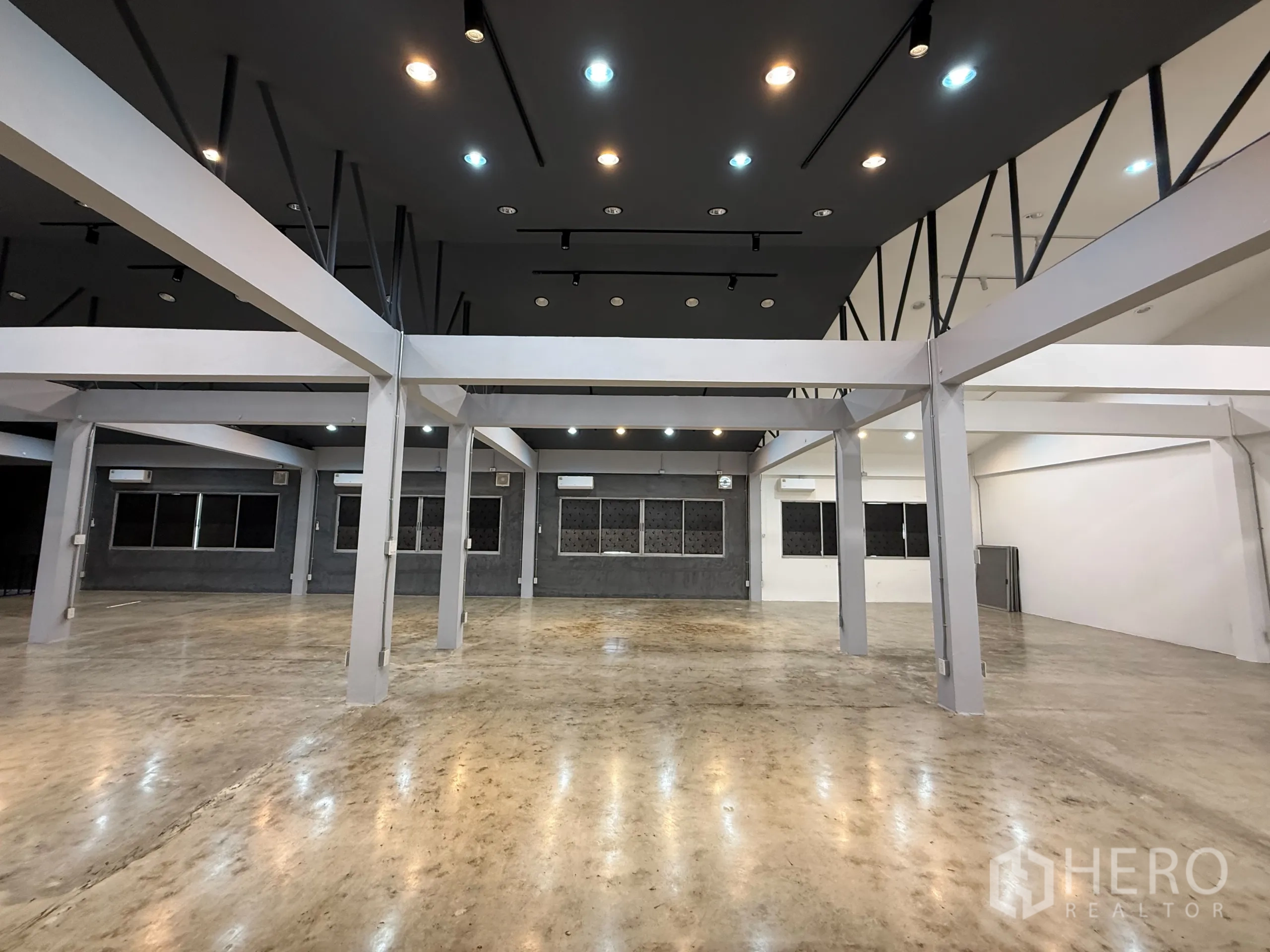 สำนักงาน ให้เช่าในWang Thonglang, Bangkok - ภาพกว้างของฮอลล์เปิดโล่ง โครงสร้างเสา พื้นปูนเรียบ และเครื่องปรับอากาศหลายจุด