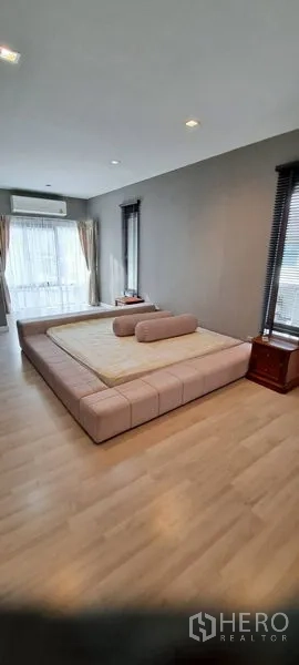 บ้าน ให้เช่าในLat Krabang, Bangkok - ห้องนอนใหญ่กว้าง พื้นไม้ เตียงแพลตฟอร์ม และหน้าต่างสูงจรดเพดาน