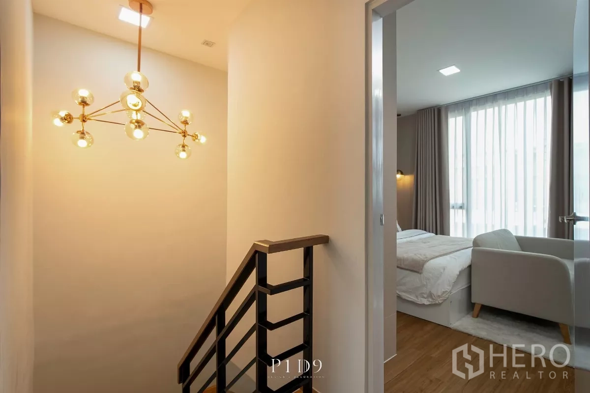 Townhouse for rent in Bang Phli, Samut Prakan - Stair landing with modern chandelier leading to an upstairs bedroom