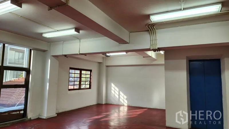 สำนักงาน ให้เช่าหรือขายในKhlong Toei, Bangkok - ออฟฟิศเปิดโล่งพื้นสีแดง หน้าต่างบานใหญ่และไฟฝ้าแบบนีออน