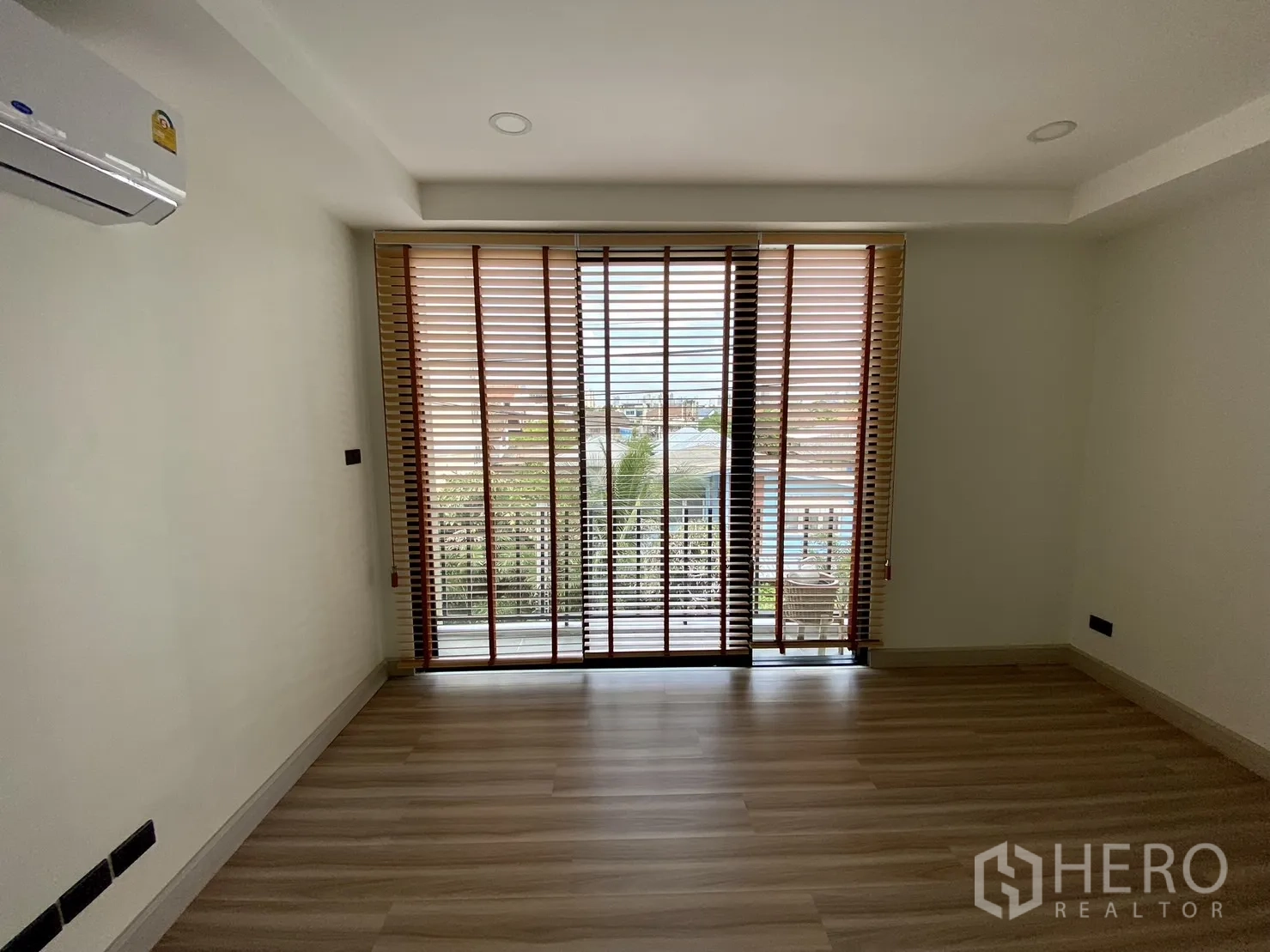 Home Office for rent or sale in Phra Khanong, Bangkok - Bedroom or office with wide balcony doors, blinds and wood laminate flooring.