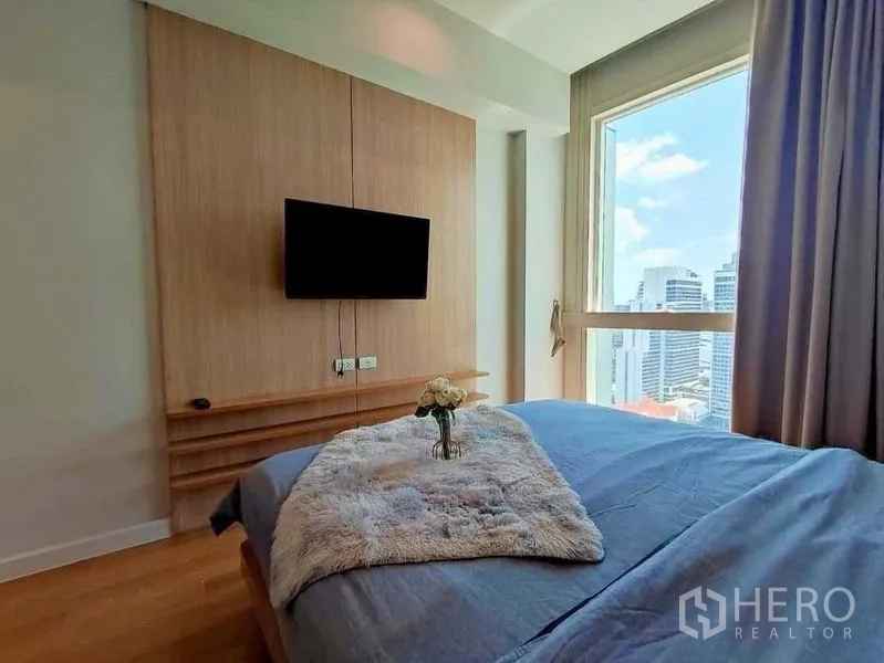 คอนโด ให้เช่าในKhlong Toei, Bangkok - ห้องนอนพร้อมทีวีติดผนัง ผ้าฟูบนเตียง และวิวเมือง