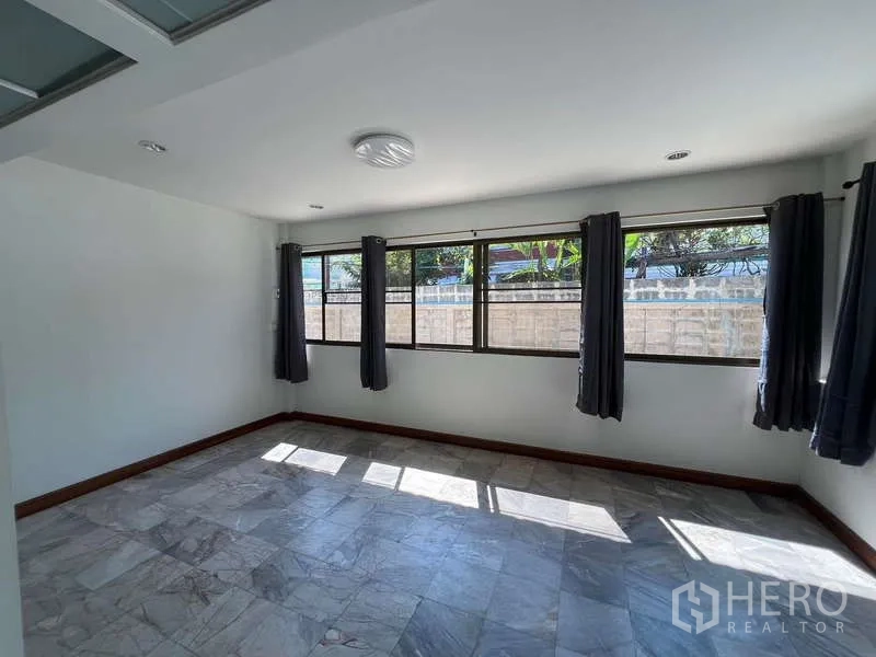 บ้าน ให้เช่าในBang Na, Bangkok - ห้องกว้าง หน้าต่างยาว ผ้าม่านสีเทา และพื้นกระเบื้องลายหิน