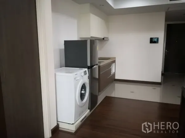 Condominium for rent in Sathon, Bangkok - Compact kitchen with washing machine, refrigerator and built‑in cabinets in a Sathon apartment.
