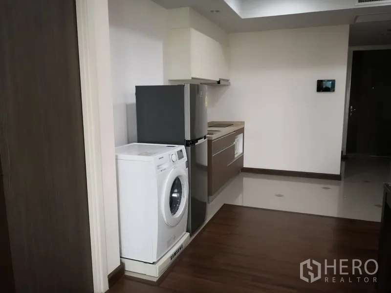 Condominium for rent in Sathon, Bangkok - Compact kitchen with washing machine, refrigerator and built‑in cabinets in a Sathon apartment.
