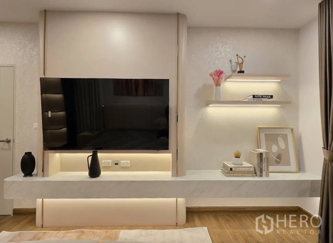 Detached House for rent or sale in Bang Phli, Samut Prakan - Media wall with large flat‑screen TV, floating console and lit display shelves.