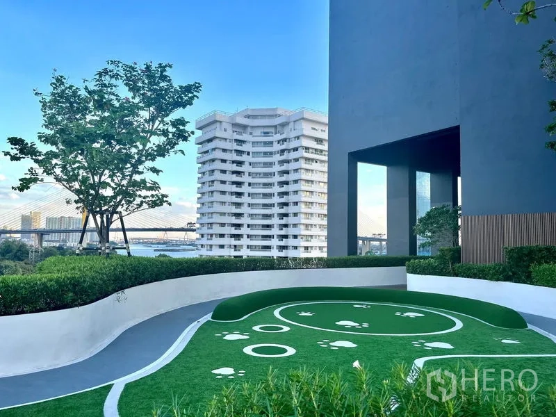 Condominium for rent or sale in Bangkok - Outdoor pet-friendly lawn with paw-print design, skyline and river bridge views.