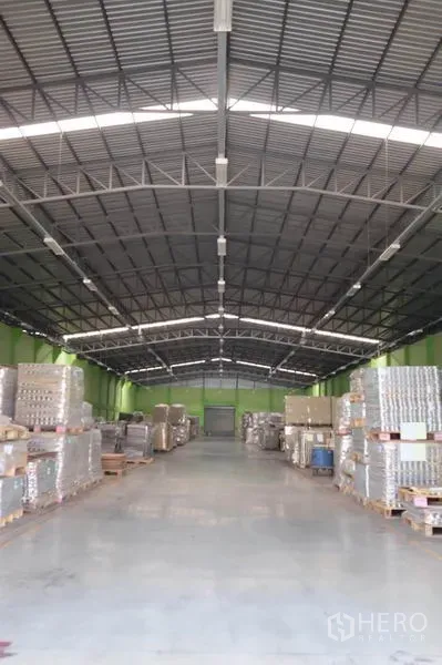 货栈 出租在Ban Phaeo, Samut Sakhon - 仓库内部通透，钢结构高屋顶，照明充足，混凝土地面，宽阔通道与整齐托盘。