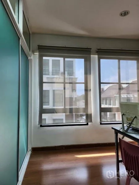 ทาวน์เฮาส์ ให้เช่าหรือขายในWang Thonglang, Bangkok - ห้องมุมมีหน้าต่างสูงสามบาน ม่านม้วน มองเห็นทาวน์เฮ้าส์ใกล้เคียง