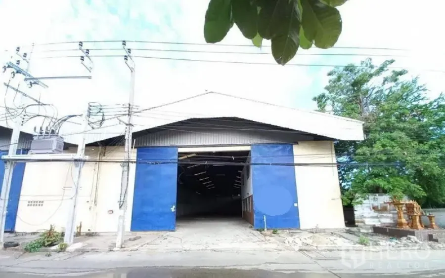 คลังสินค้า ให้เช่าในMueang Samut Prakan, Samut Prakan - ด้านหน้าโกดังสมุทรปราการ ประตูบานเลื่อนสีน้ำเงิน หลังคาทรงจั่ว ทางรถเข้าออกสะดวก